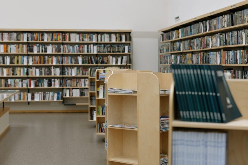 Spacious university library featuring wooden bookshelves filled with diverse books for education and research.